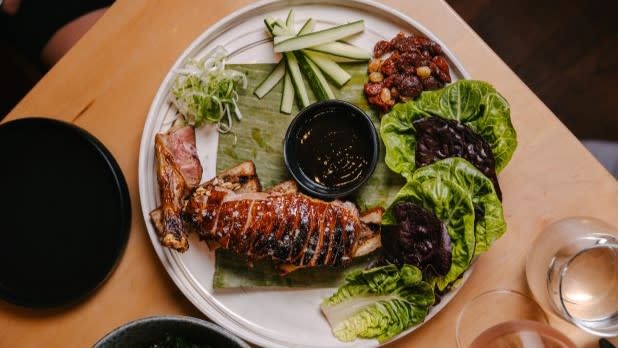 A plate of duck and green vegetables
