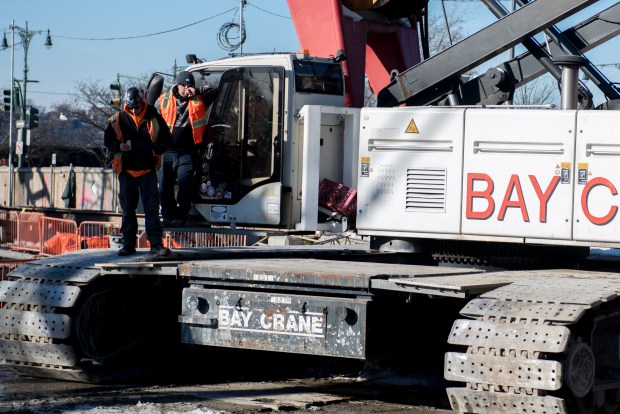 Two construction workers stand on an idle crane Thursday, Feb. 5, 2026, in Manhattan. GDC officials say the funding freeze will require them to lay off 1,000 workers this weekend. (Evan Simko-Bednarski / New York Daily News)