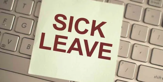 sticky note reading "sick leave" on desk top keyboard; NYC's DCWP Releases Updated ESSTA FAQs and Notice of Employee Rights