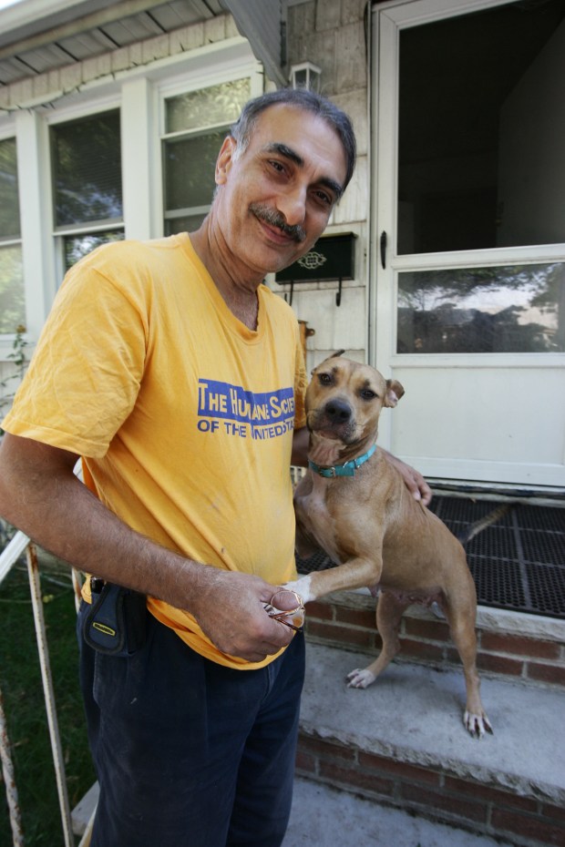 Garo Alexanian and his dog, Katrina, who he named after the hurricane when he found her in New Orleans, spend time together in Alexanian's home on 65th Ave. in Queens, New York, on Friday, Sept. 30, 2005. Katrina is a dingo mix and about three years old. (Anthony DelMundo for New York Daily News)