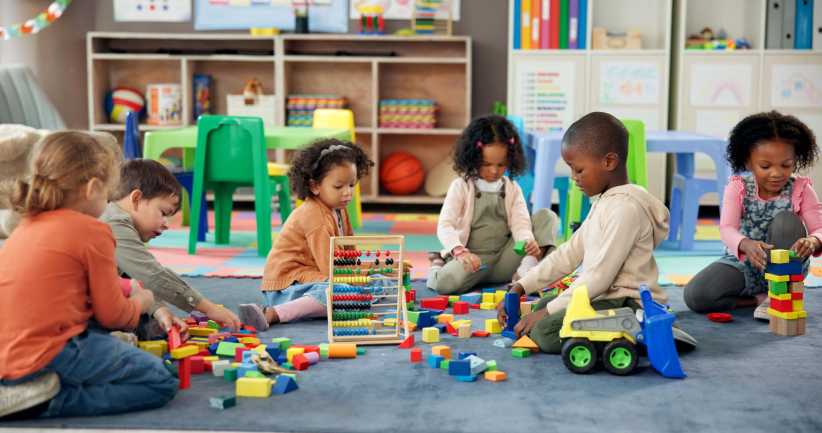 Kids, students and play with blocks in classroom for learning, problem solving and creative activity. Children, toys and floor for education game, puzzle solution and motor growth in kindergarten, Strive Charter School