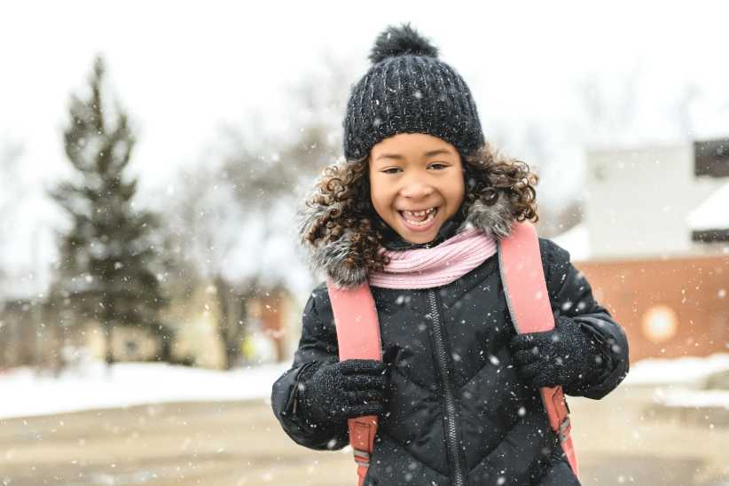 A young child leaving school with a backpack for February mid-winter break NYC