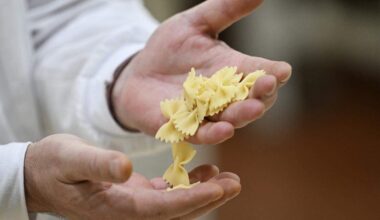 A man holds freshly made farfalle pasta.