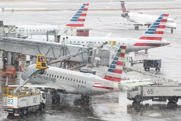 A ground crew de-ices an Embraer ERJ-175 American Eagle passenger plane at LaGuardia Airport in New York on Feb. 22, 2026. A fast-developing storm is threatening to pummel the East Coast with a foot or more of snow beginning Sunday, bringing Mother Nature's wrath to a region that only just dug out from a previous winter wallop. Meteorologists issued blizzard warnings for New York and parts of at least six states, warning Saturday that heavy snow and gale-force winds are forecast to slam all major cities along the densely populated Interstate 95 northeast corridor, including Philadelphia, Boston and even Washington further south. (Photo by CHARLY TRIBALLEAU / AFP via Getty Images)