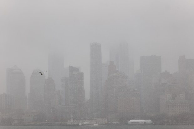 The New York City skyline is partly obscured by snow as the city braces for a blizzard on Sunday, Feb. 22, 2026, in New York City.