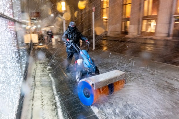 A person is seen using a snowblower as the city braces for a blizzard on Sunday, Feb. 22, 2026, in New York City.