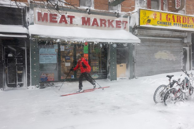 A man skis through the streets of Brooklyn as blizzard conditions continue on Feb. 23, 2026, in New York City.