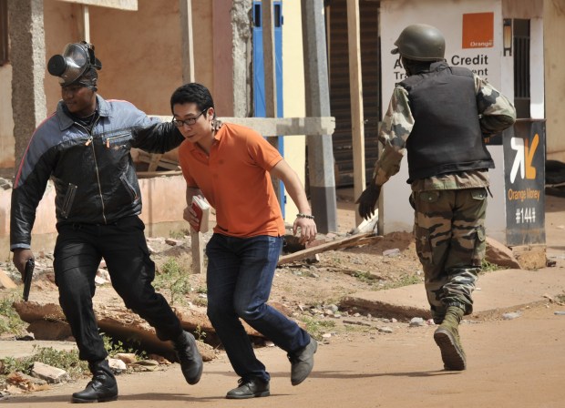 Malian security forces evacuate a man from an area surrounding the Radisson Blu hotel in Bamako on November 20, 2015. (HABIBOU KOUYATE/AFP via Getty Images)