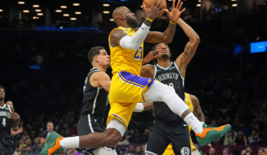 Los Angeles Lakers' LeBron James, center, drives past Brooklyn Nets' Nic Claxton, right, and Michael Porter Jr. during the first half of an NBA basketball game Tuesday, Feb. 3, 2026, in New York. (AP Photo/Frank Franklin II)