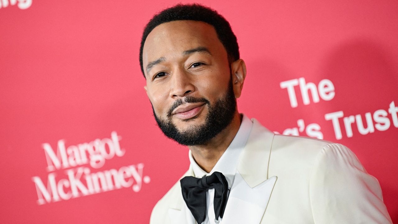 john legend smiles from a red carpet premiere