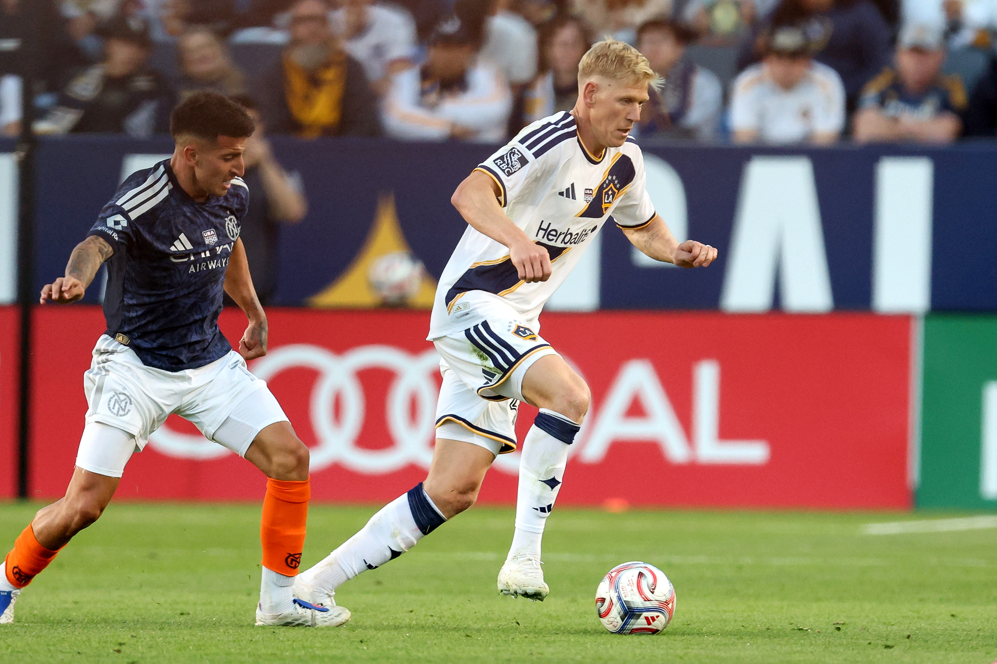 Galaxy defender Jakob Glesnes, right, moves the ball against the...