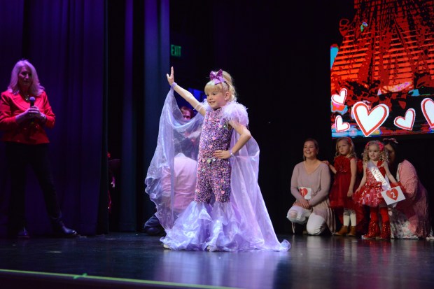 Last year's Little Miss Valentine, four-year-old McKinlee Polston, shows off her glitzy purple outfit. (Sharla Steinman/ Loveland Reporter-Herald)