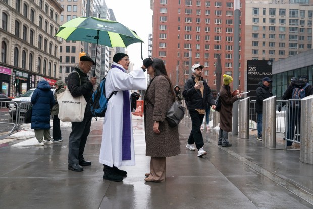 Father Fabian Arias gives out ashes outside the Jacob Javits Federal Building Wednesday, Feb. 18, 2026 in Manhattan, New York. (Barry Williams/ New York Daily News)