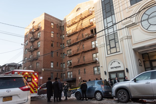 Neighbors and emergency workers gather at the scene of a fatal fire in an apartment building on 47th Street near 12th Ave. in Brooklyn, New York City on Thursday, February 5, 2026. (Gardiner Anderson / New York Daily News)