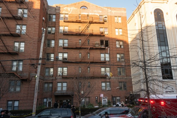 Neighbors and emergency workers gather at the scene of a fatal fire in an apartment building on 47th Street near 12th Ave. in Brooklyn, New York City on Thursday, February 5, 2026. (Gardiner Anderson / New York Daily News)