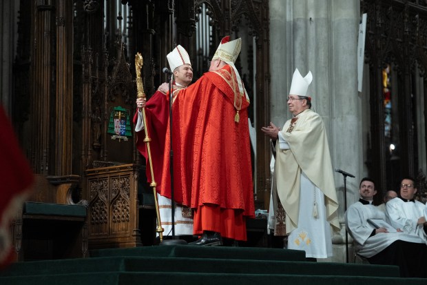 Timothy Cardinal Dolan gives his seat to Archbishop Ronald Hicks, signifying Hicks officially becoming Archbishop of New York, at St. Patricks Cathedral on Friday. 