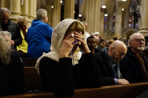 A woman prays during the installation Mass for Archbishop-designate of New York Ronald Hicks at St. Patrick's Cathedral on Friday. 