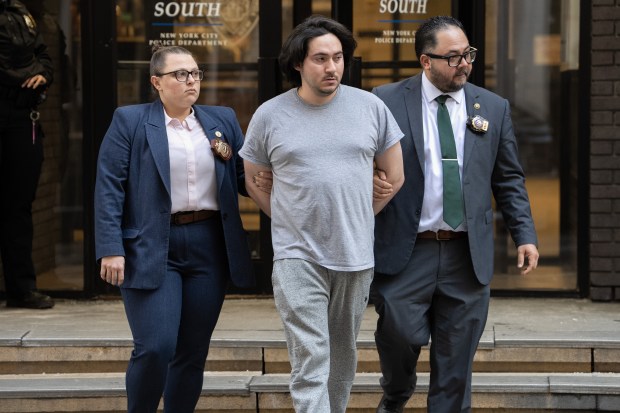 Michael Santiago is pictured in custody outside the Midtown South Precinct station house on Thursday.