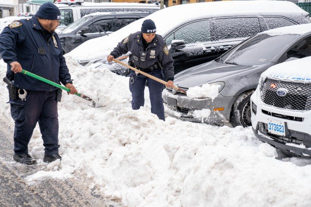 NYPD officers clear away snow outside of the 67th Precinct stationhouse on Snyder Ave. in Brooklyn on Monday, January 26, 2026. (Theodore Parisienne / New York Daily News)