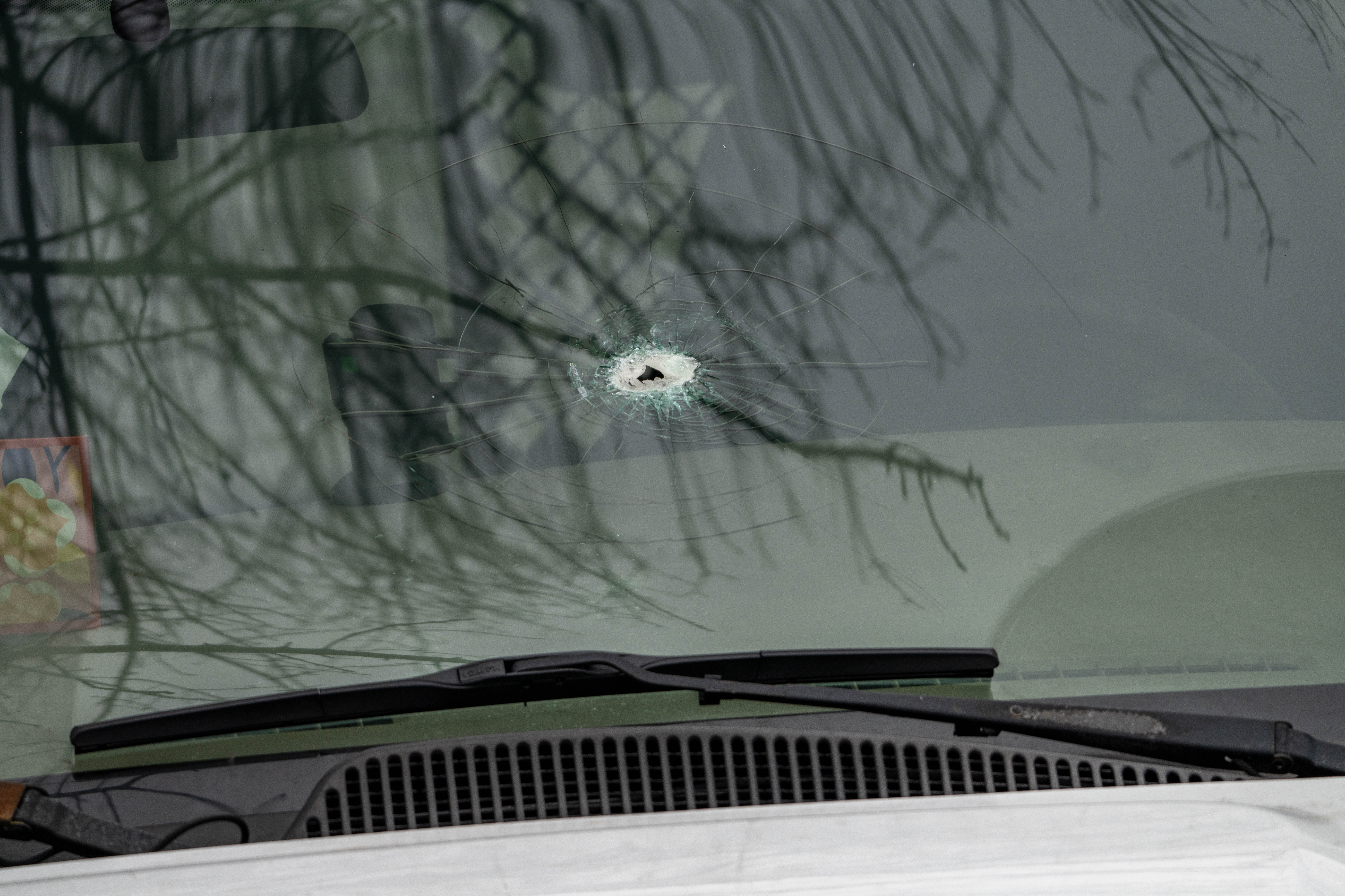 Two bullet holes are seen here in this parked Chevy...