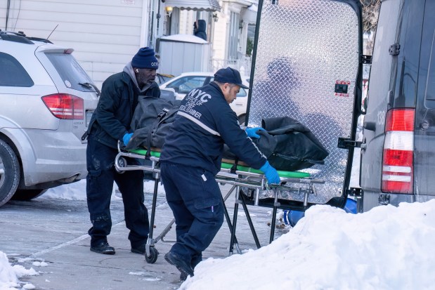 Medical Examiner workers remove the body of a man found dead inside a mobile veterinary van on 65th Ave. and Parsons Blvd. in Queens Sunday morning.