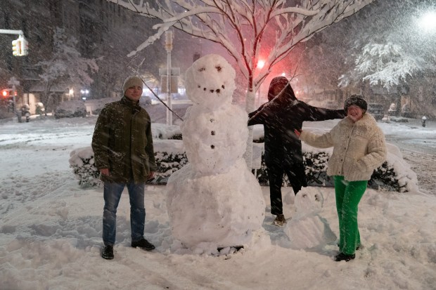People pose with a snowman on Park Ave. on the Upper East Side of Manhattan during a snow storm Sunday, Feb. 22, 2026 in New York City. (Barry Williams/ New York Daily News)