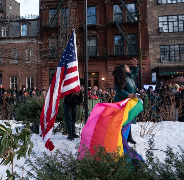 An LGBTQ supporter lowers a U.S. flag to be joined with a pride flag at the Stonewall National Monument on Feb. 11, 2026 in Manhattan.