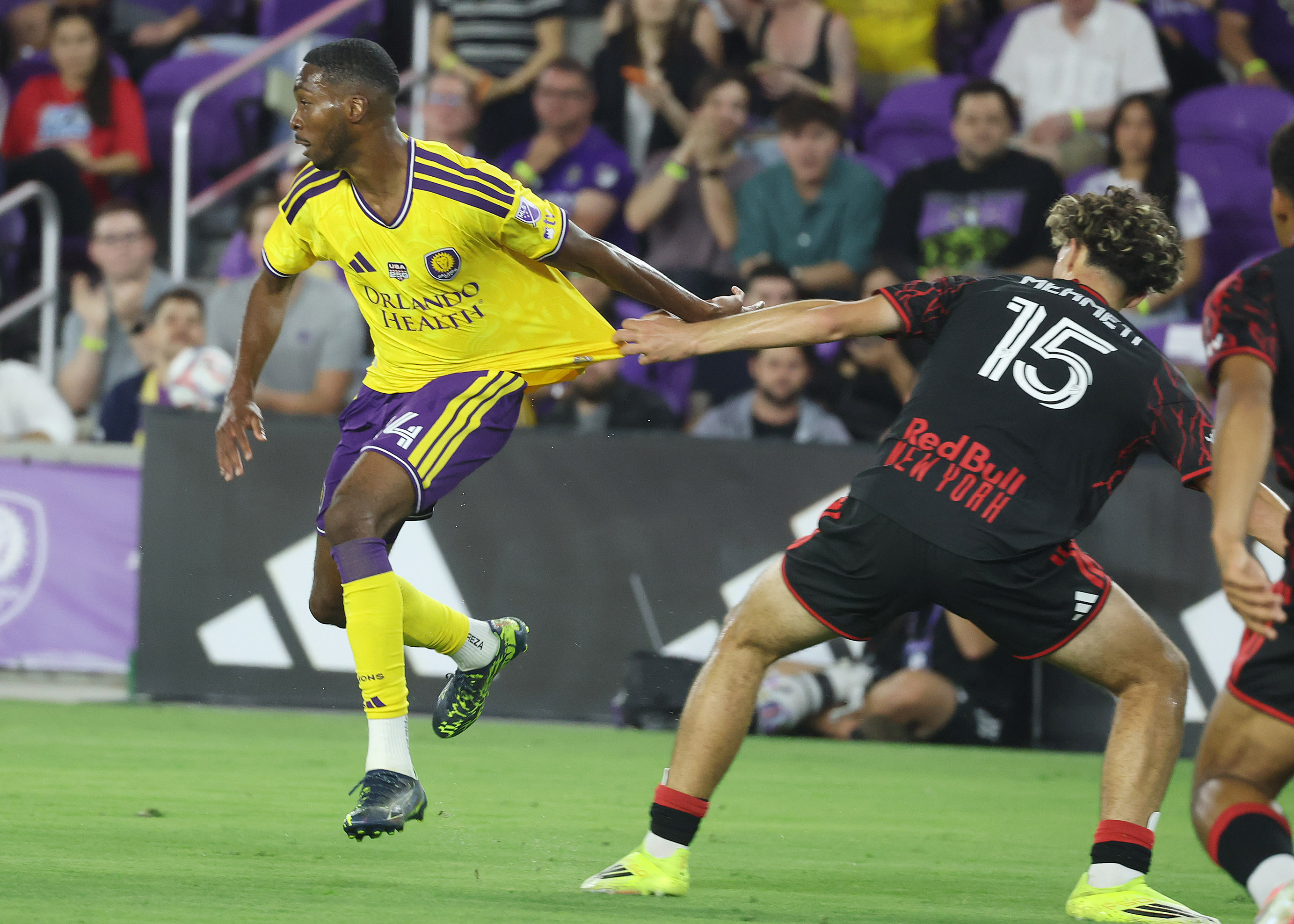 New York player Mehmeti (15) pulls the jersey of Orlando...