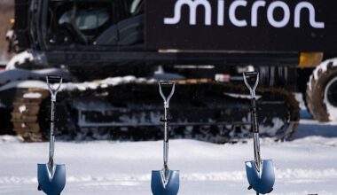 micron shovels in ground, implement in the background