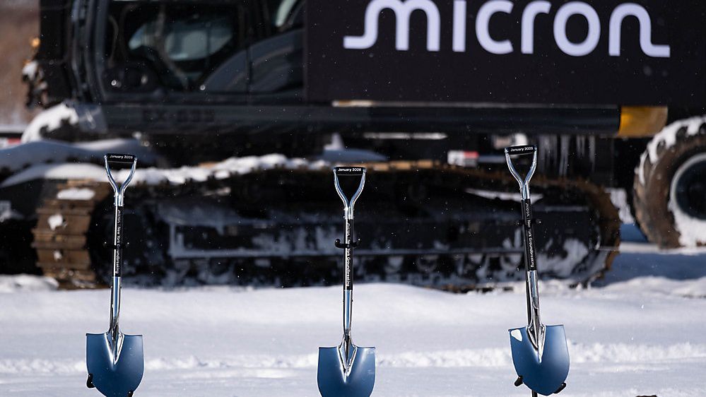 micron shovels in ground, implement in the background