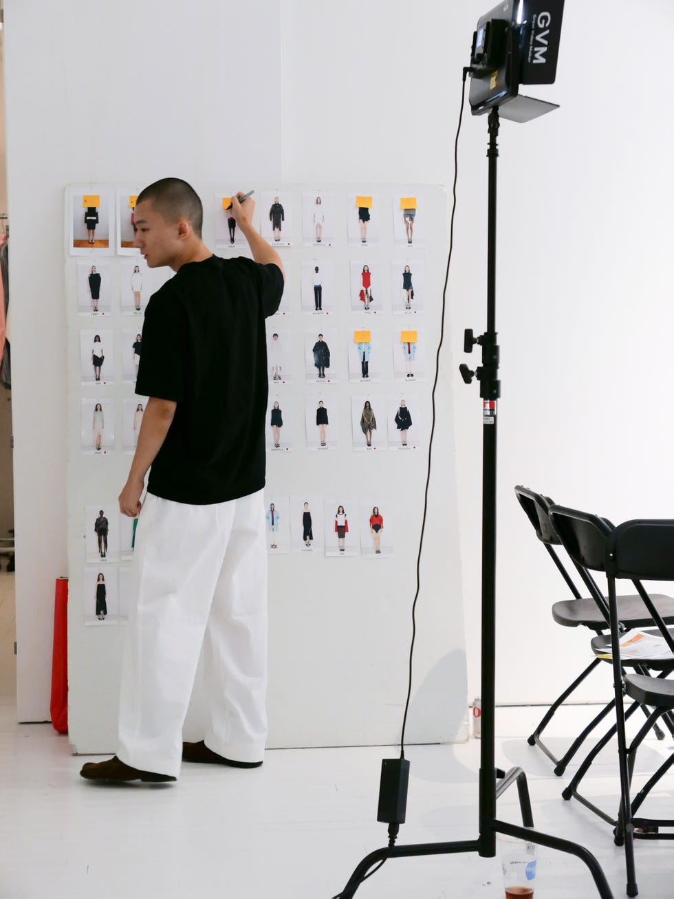 Fashion stylist reviewing a mood board with garment images.