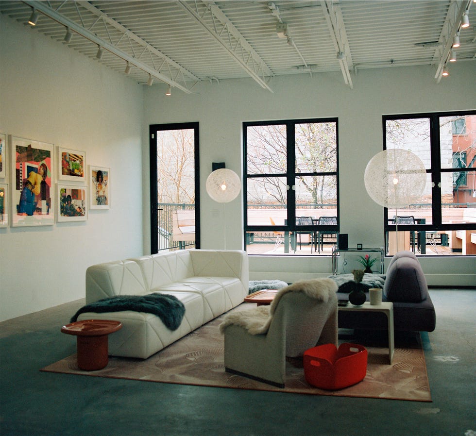 Modern living space with artwork, seating, and natural light.