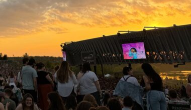 crowd at empower amphitheater with the sun setting behind the main stage