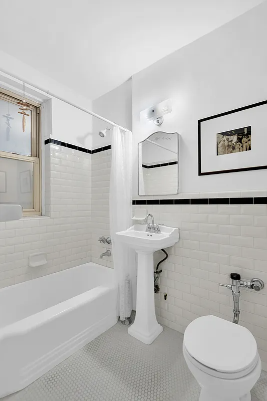 bathroom with white fixtures and tile with a black accent tile