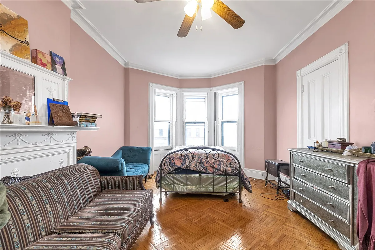 bedroom with pink walls, white mantel
