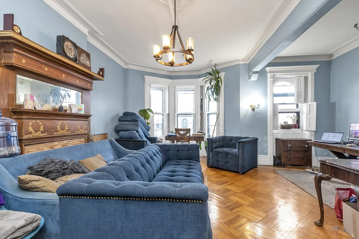 living room of upper duplex with blue walls, a wood mantel