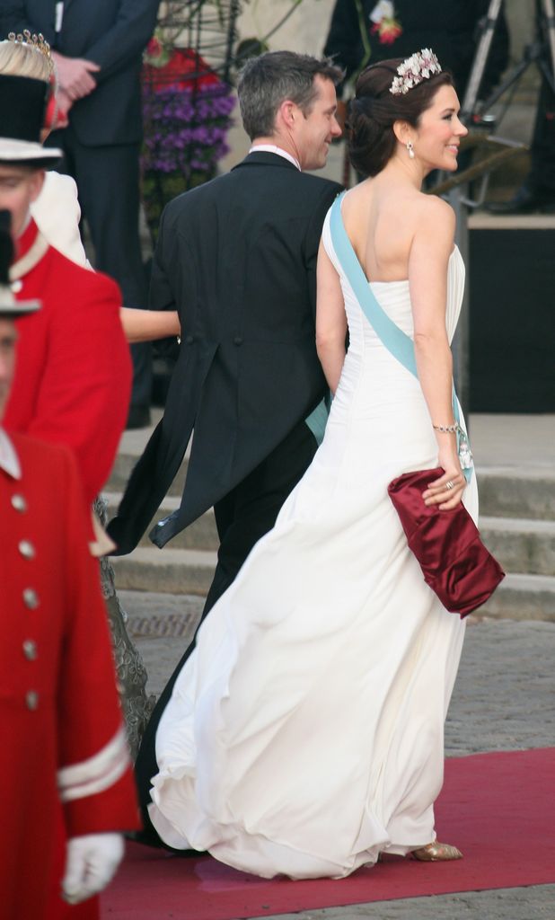 Queen Mary with her hair up in white dress beside frederik from back