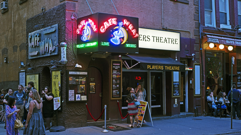 Outside Cafe Wha? with lit sign in Greenwich Village, NYC