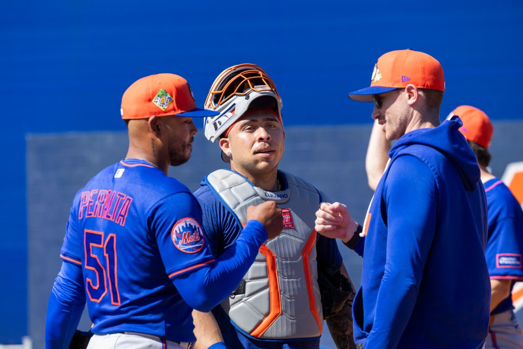 New York Mets pitcher Freddy Peralta (51), catcher Francisco Alvarez, and pitching coach Justin Willard confer during Spring Training.