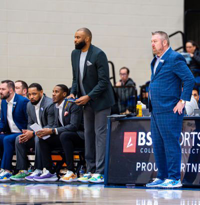 Queens basketball coaches on sidelines