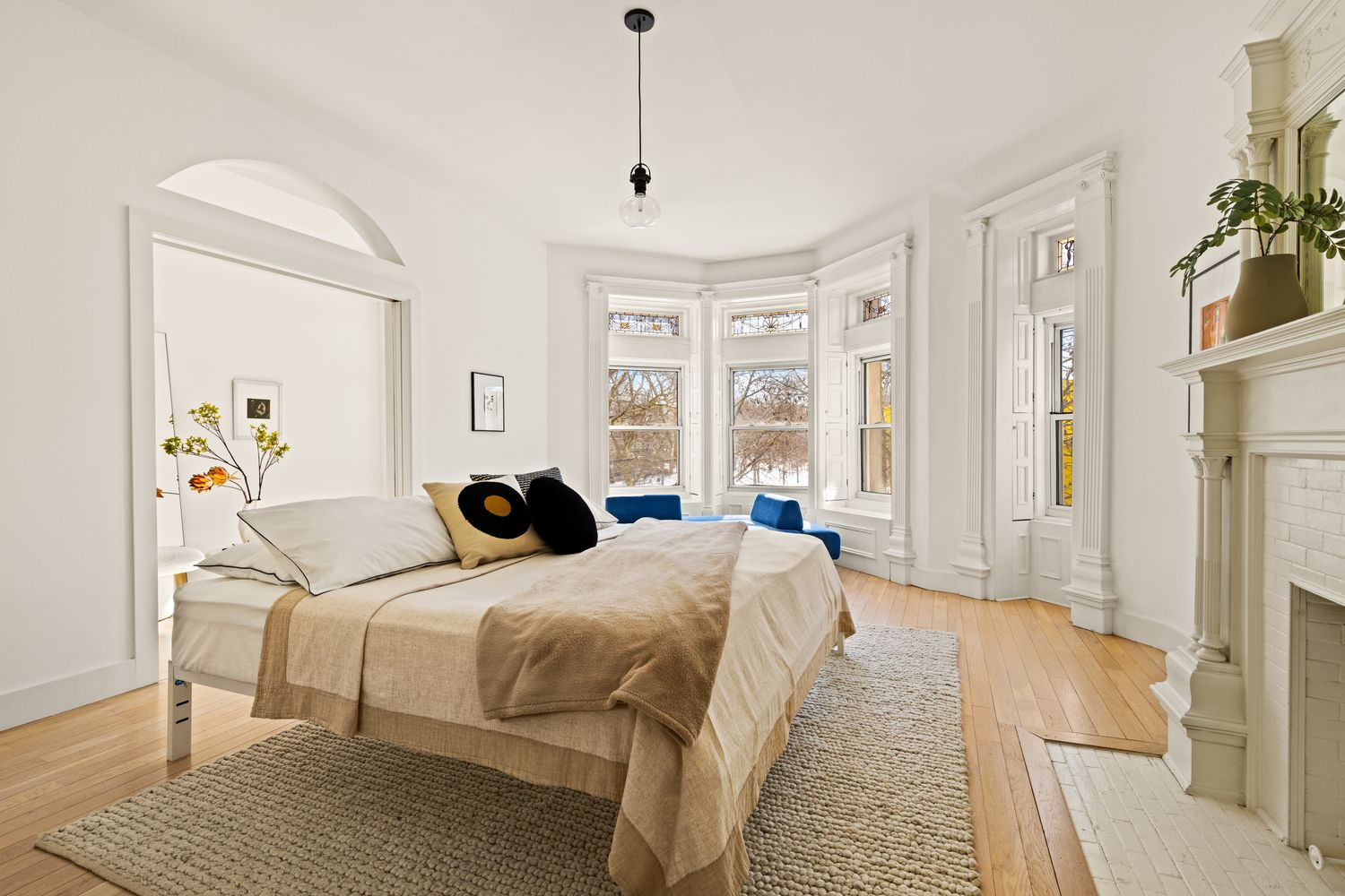 bedroom with mantel, moldings, access to a dressing room