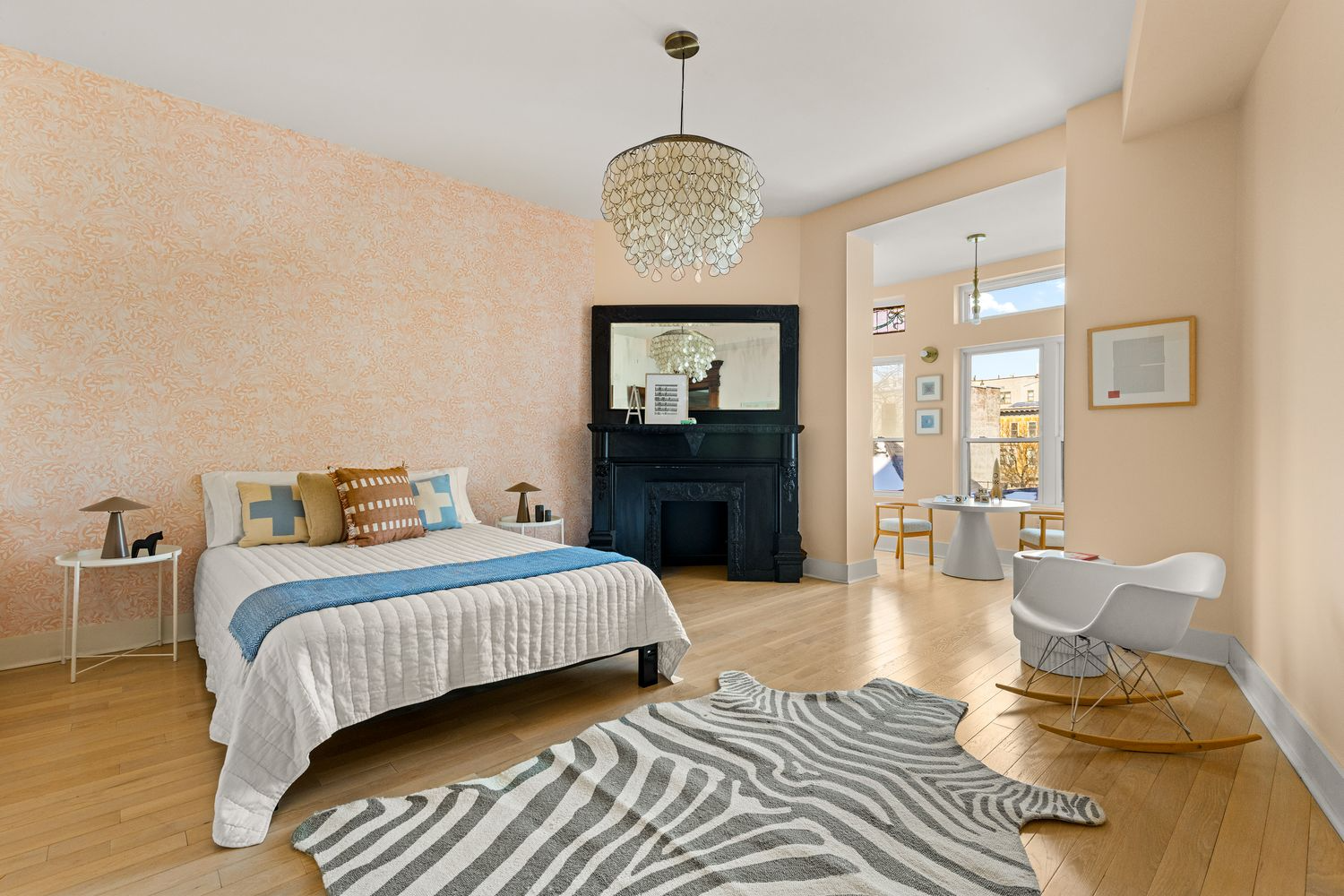 second floor room with a corner fireplace set up as a bedroom with access to a sunroom