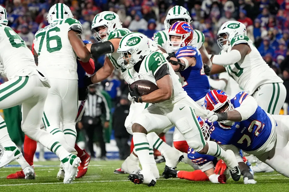 Jan 4, 2026; Orchard Park, New York, USA; New York Jets running back Khalil Herbert (31) avoids a tackle by Buffalo Bills defensive tackle Phidarian Mathis (72) during the third quarter at Highmark Stadium. Mandatory Credit: Gregory Fisher-Imagn Images