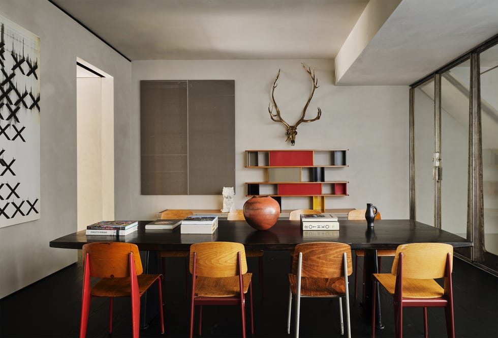 Modern dining area with a wooden table and colorful chairs.