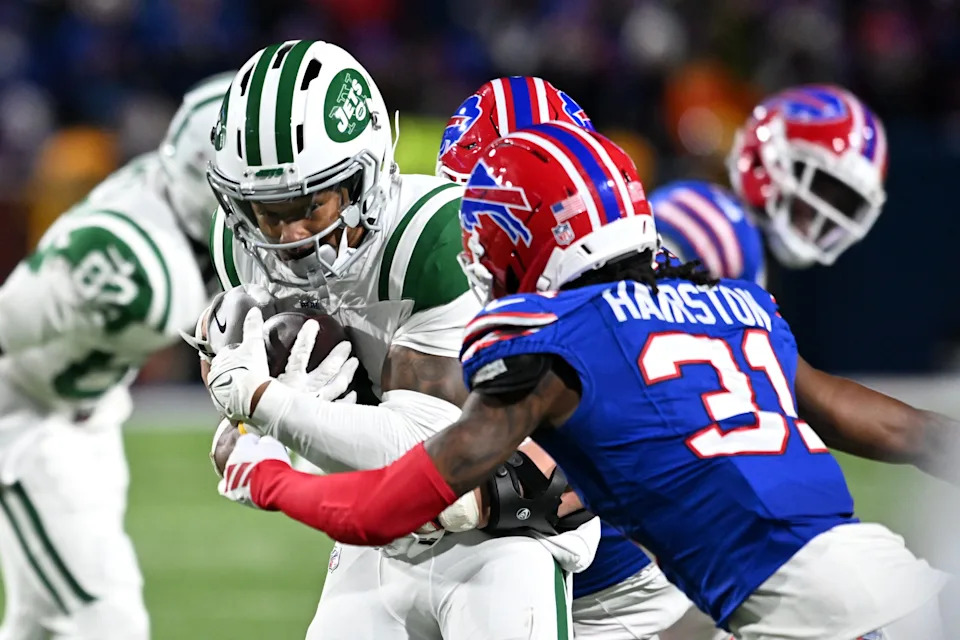 Jan 4, 2026; Orchard Park, New York, USA; New York Jets wide receiver John Metchie III (3) carries the ball defended by Buffalo Bills cornerback Maxwell Hairston (31) during the fourth quarter at Highmark Stadium. Mandatory Credit: Mark Konezny-Imagn Images