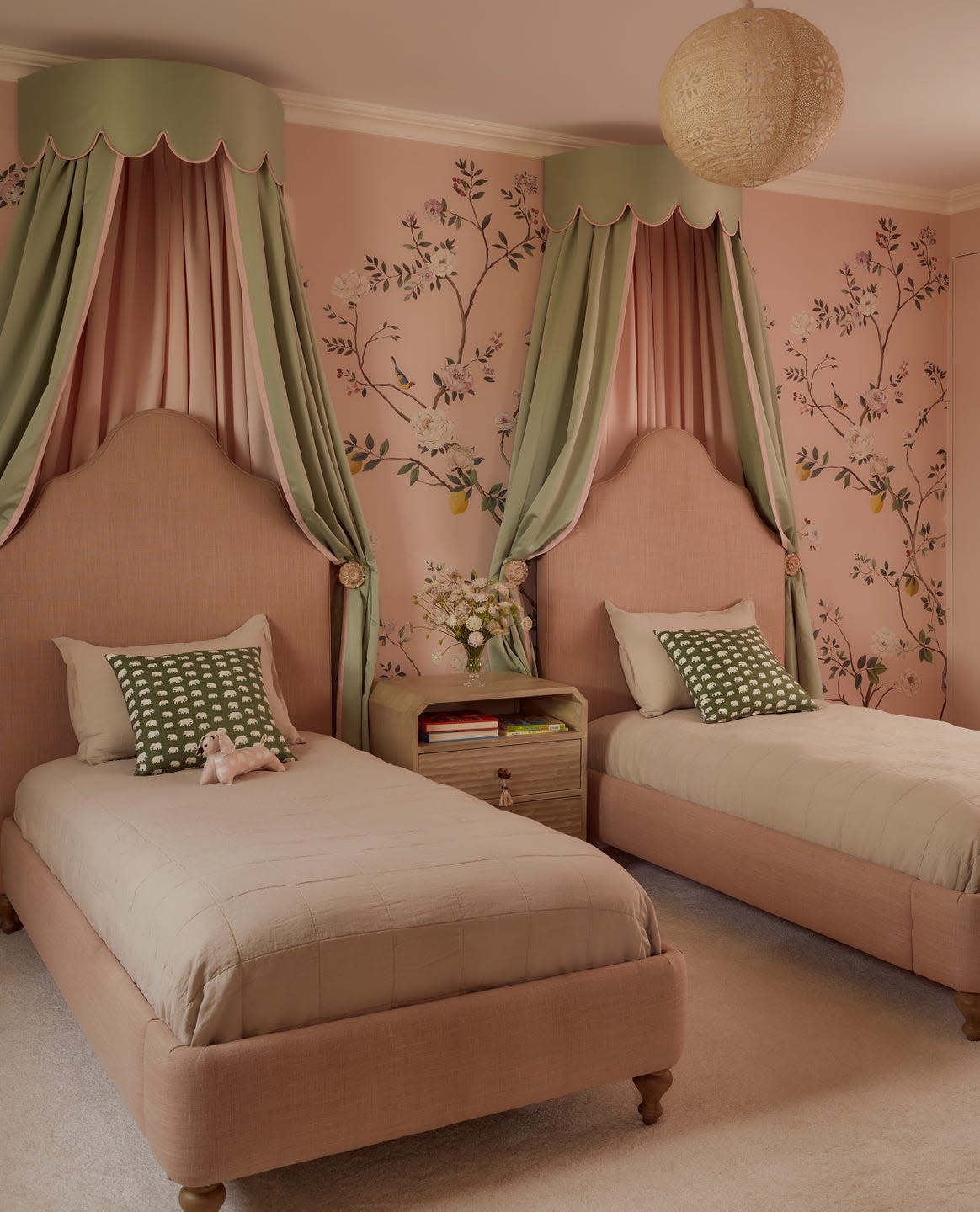 Children's bedroom with two beds and floral wallpaper.