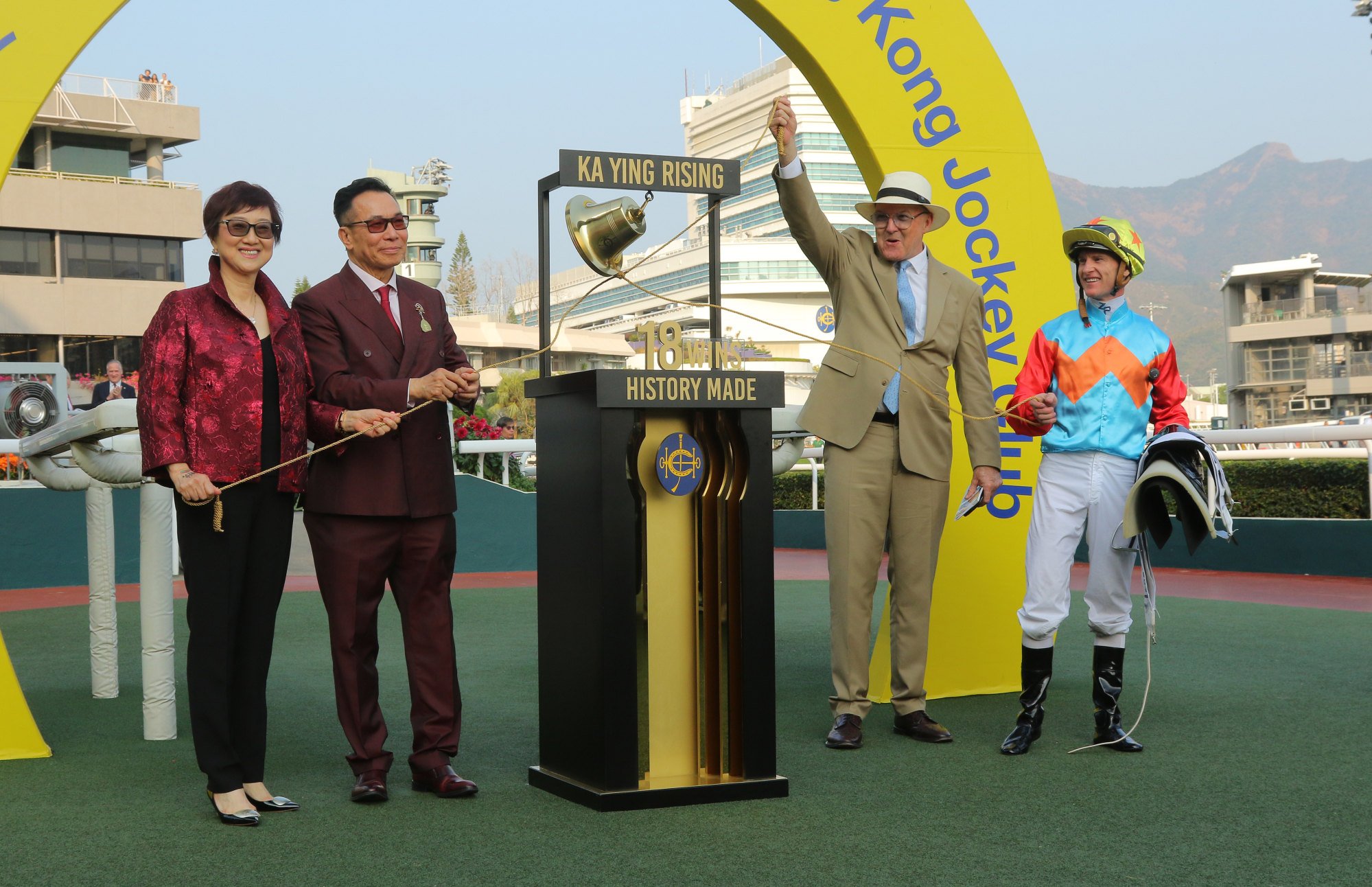 Trainer David Hayes (second from right), jockey Zac Purton and connections of Ka Ying Rising ring the commemorative bell.