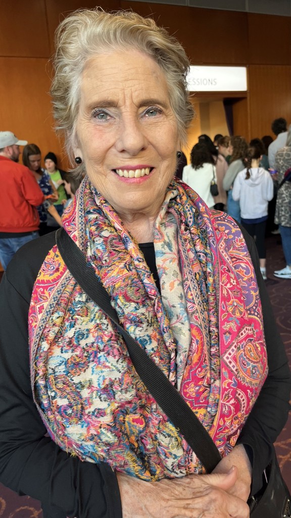 Elizabeth Childs-Johnson poses for a photo while wearing a colorful scarf. 
