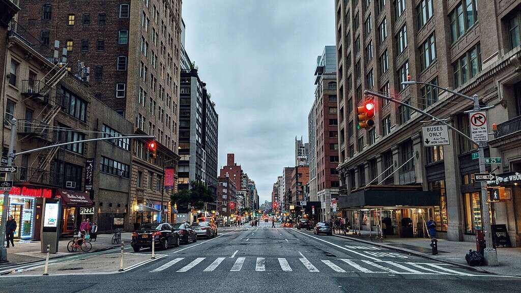 Traffic lights and urban street scene in Manhattan, New York City, during cloudy weather.