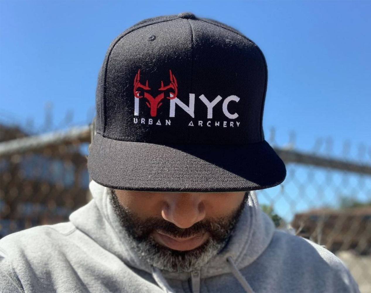 A man in a black hat that's a riff on hunting NYC